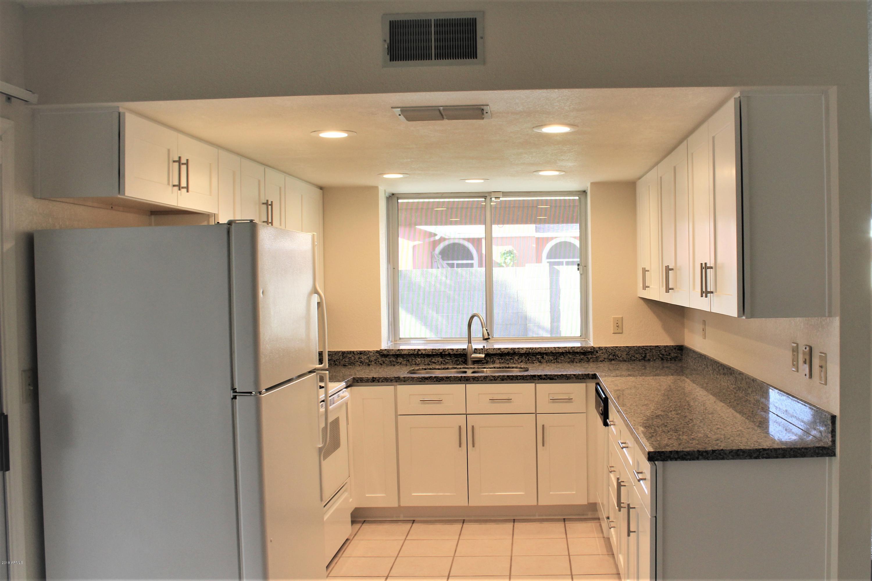 5940 East Spring Road Scottsdale, AZ 85254 - Photo 5 of 23 a kitchen with stainless steel appliances granite countertop a refrigerator and a sink