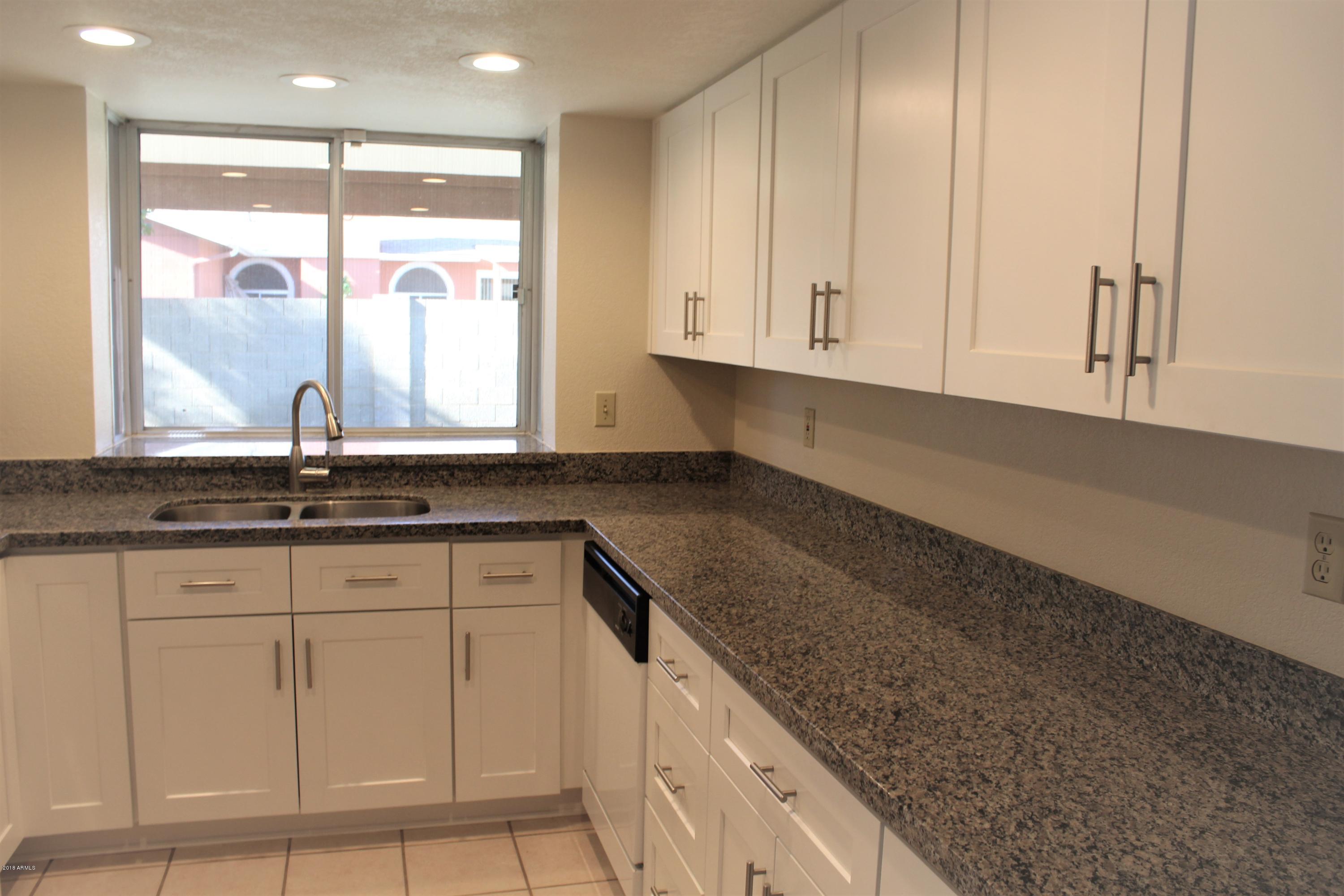 5940 East Spring Road Scottsdale, AZ 85254 - Photo 6 of 23 a kitchen with granite countertop white cabinets and a sink