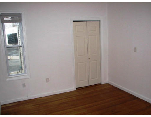 19 Burrell Street Boston, MA 02119 - Photo 8 of 20 an empty room with wooden floor and windows