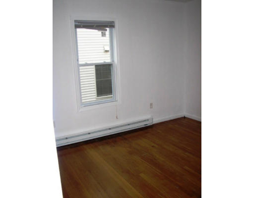 19 Burrell Street Boston, MA 02119 - Photo 9 of 20 a view of an empty room with wooden floor and a window