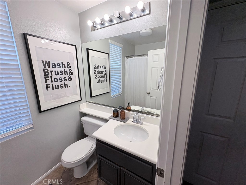 2729 Hornbeam Road Palmdale, CA 93551 - Photo 19 of 35 a bathroom with a sink a toilet a mirror and shower