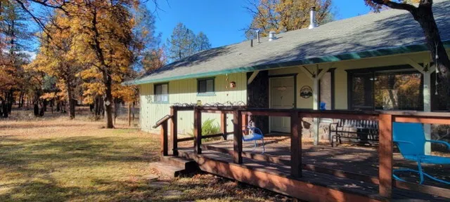 a view of a house with large windows and a table and chairs
