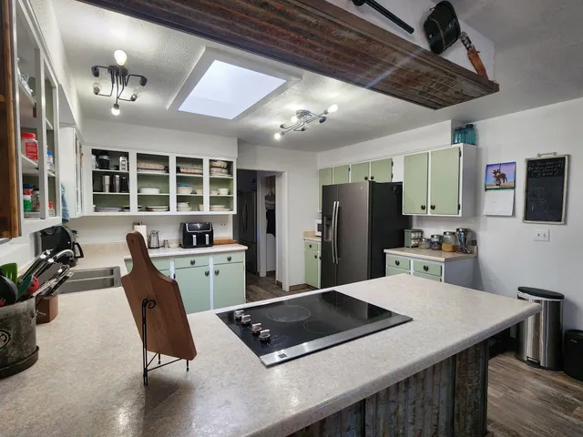 a kitchen with a table chairs refrigerator and cabinets