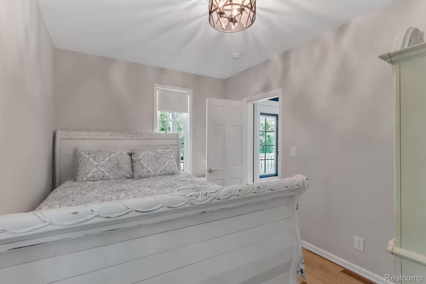 4567 North Seymour Road Flushing, MI 48433 - Photo 24 of 43 Bright room featuring a window with natural light, a neutral color palette, wood-finish flooring, and a decorative ceiling fixture