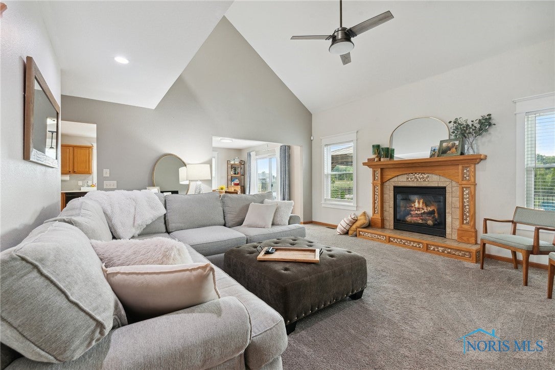 166 Lawai Road Oregon, OH 43616 - Photo 9 of 48 Main floor living room with vaulted ceilings, ceiling fan, gas fireplace with fan. Gorgeous windows and trim added in December.