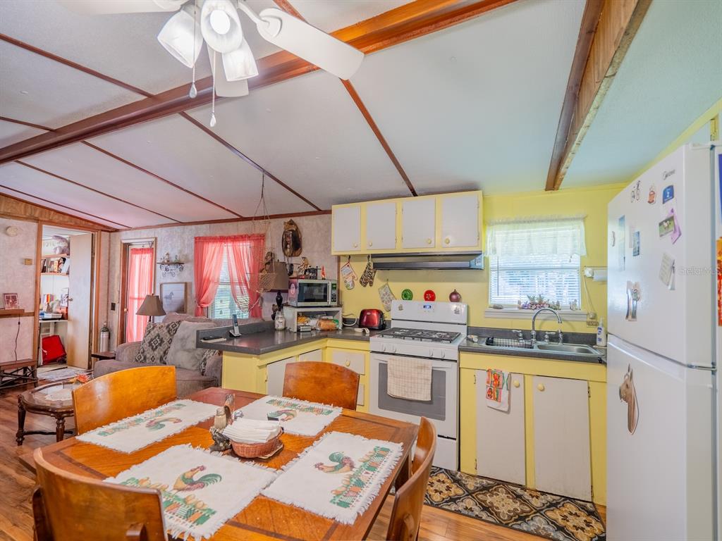 15429 Northeast 38th Court Citra, FL 32113 - Photo 12 of 53 a open kitchen with stainless steel appliances granite countertop a stove a sink dishwasher and white cabinets with wooden floor