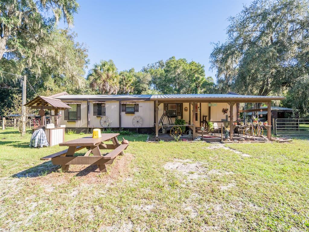 15429 Northeast 38th Court Citra, FL 32113 - Photo 2 of 53 a house view with swimming pool and wooden bench