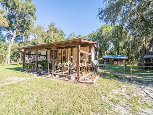 a view of a chairs and table in backyard of the house