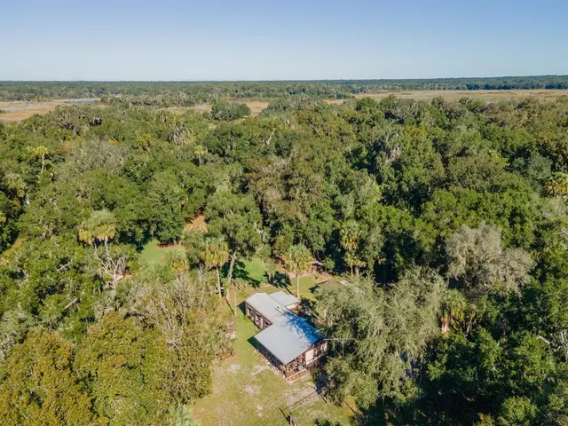 an aerial view of residential house with yard and outdoor seating