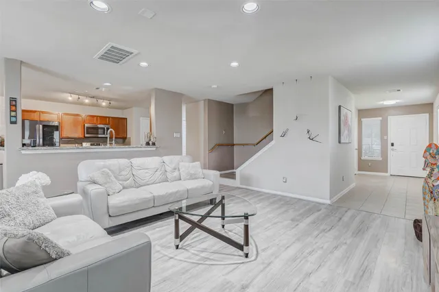 a living room with furniture and a wooden floor
