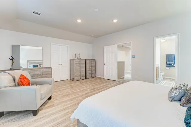 a spacious bedroom with a bed and a couch