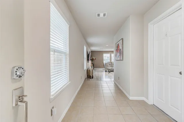 a view of a hallway with a livingroom and a window