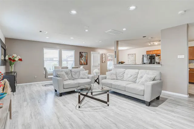 a living room with furniture and a wooden floor