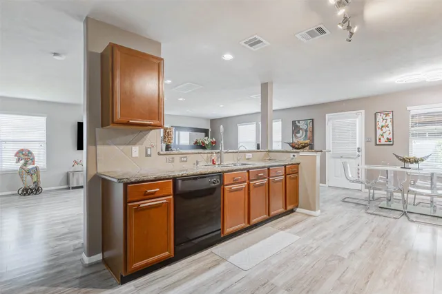 a large kitchen with stainless steel appliances granite countertop a sink counter space and wooden floor