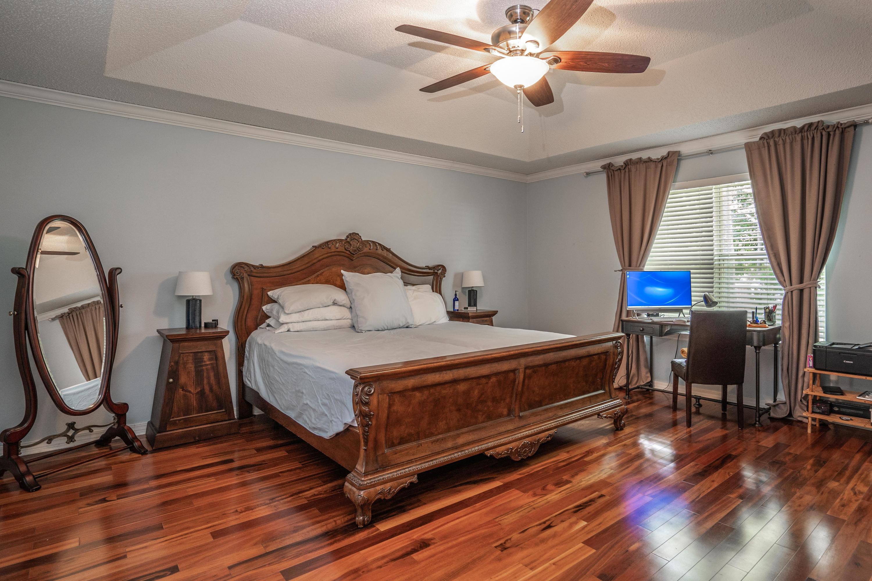 4258 Shadow Lane Niceville, FL 32578 - Photo 15 of 36 a bedroom with a bed a dresser and wooden floor