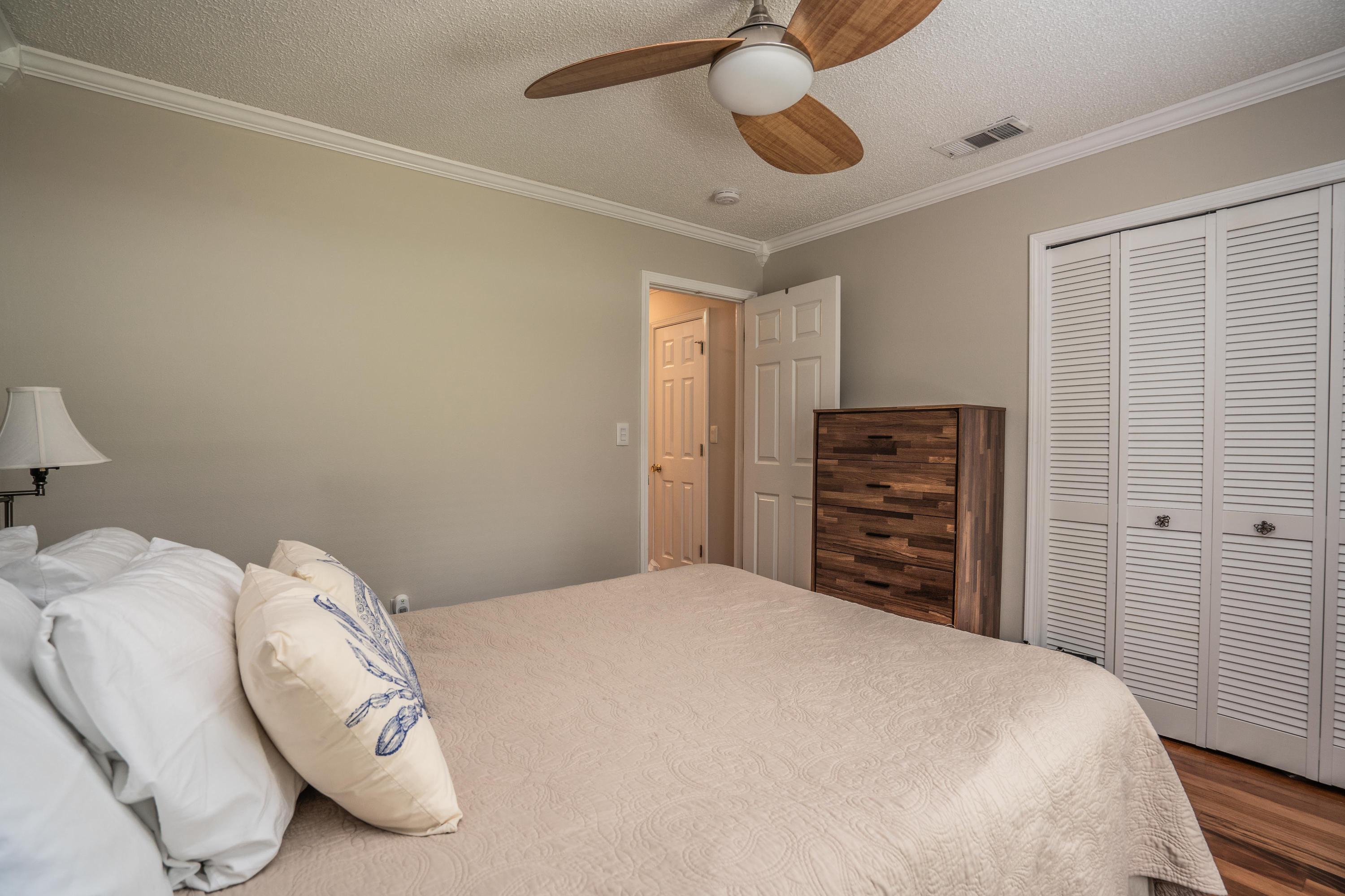 4258 Shadow Lane Niceville, FL 32578 - Photo 23 of 36 a bedroom with a bed and a chandelier