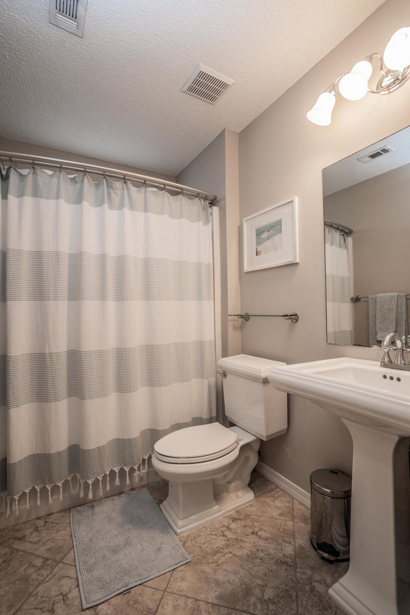 4258 Shadow Lane Niceville, FL 32578 - Photo 25 of 36 a bathroom with a sink a toilet a mirror and shower curtain