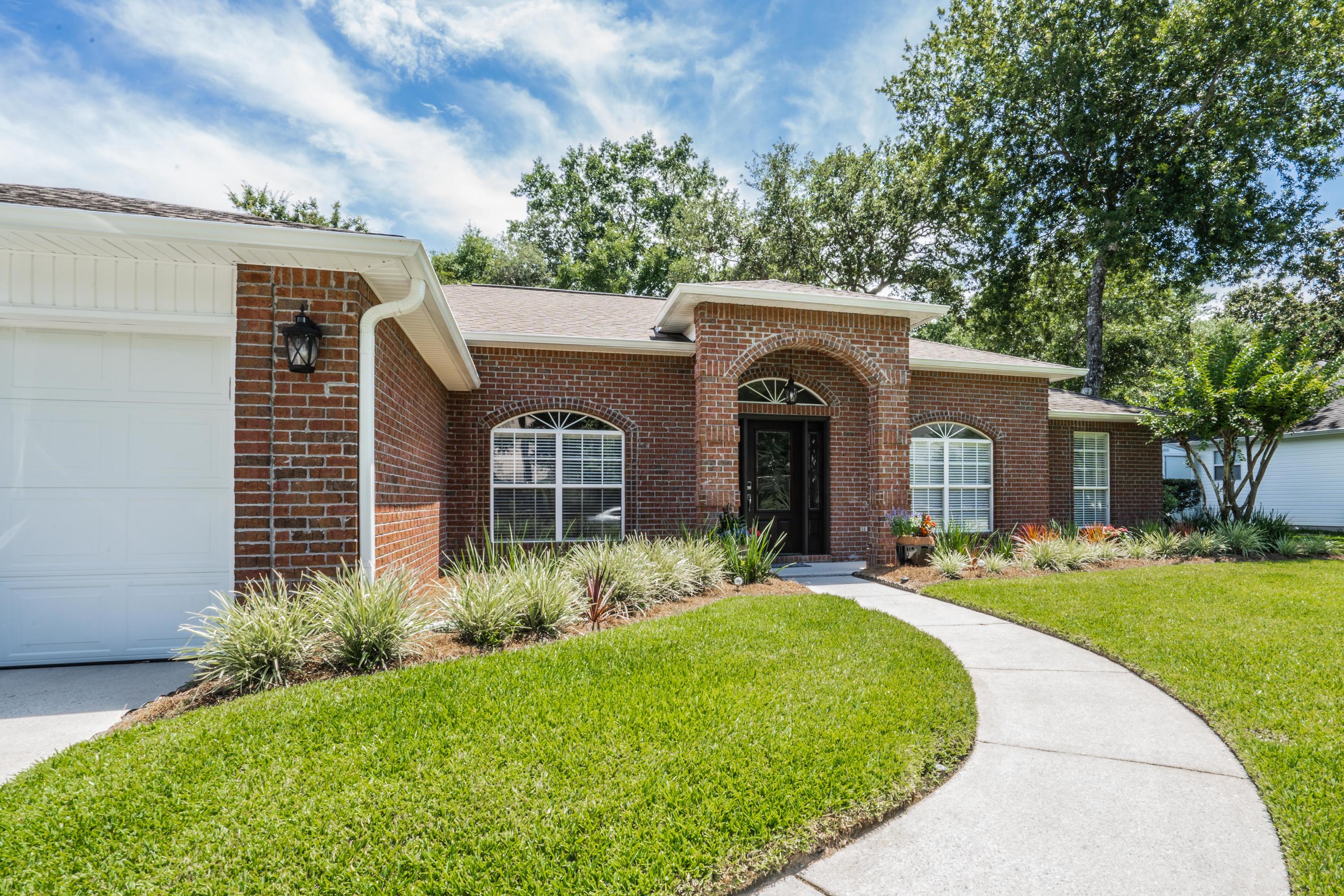 4258 Shadow Lane Niceville, FL 32578 - Photo 3 of 36 a front view of a house with garden
