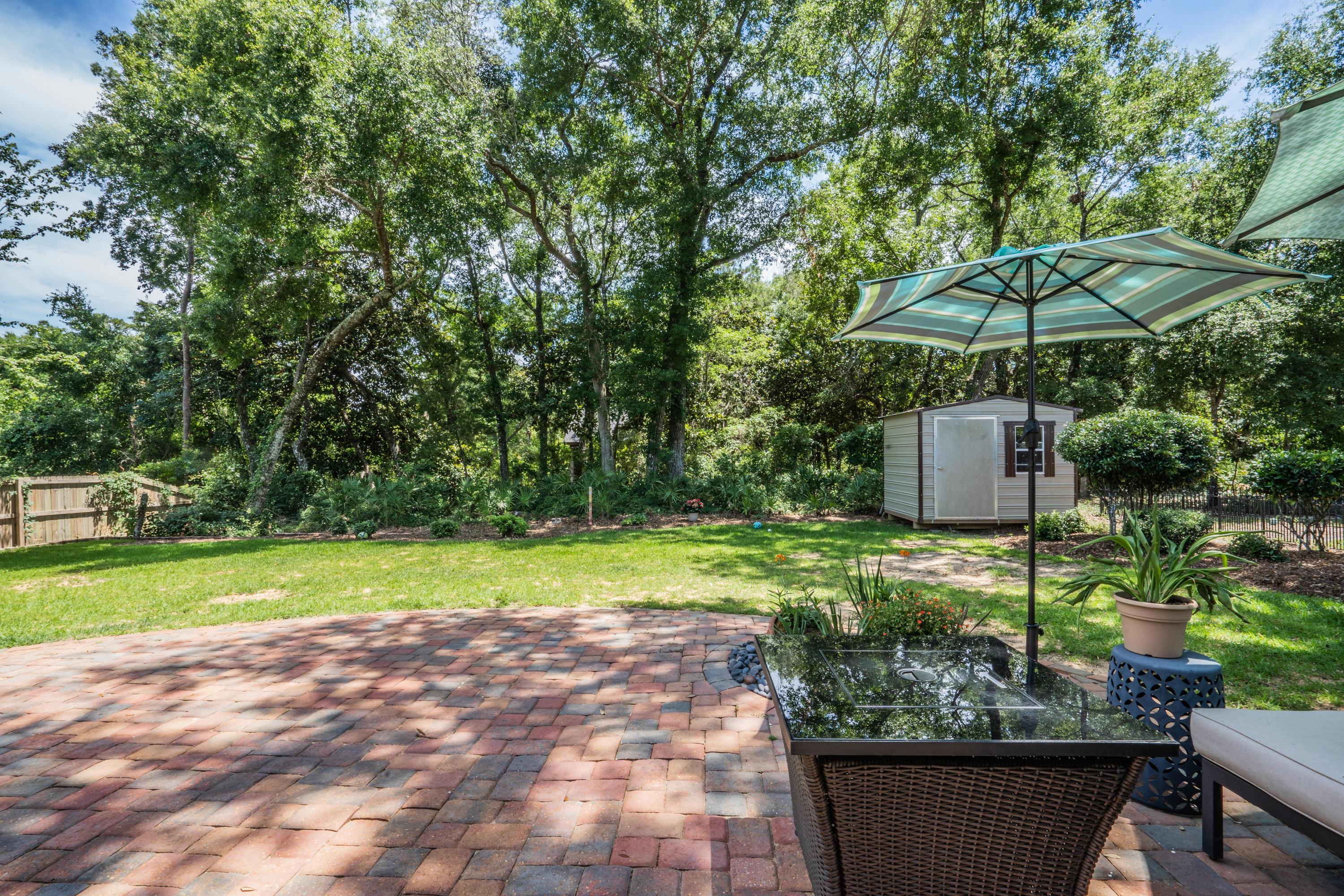 4258 Shadow Lane Niceville, FL 32578 - Photo 36 of 36 a view of a backyard with table and chairs under an umbrella