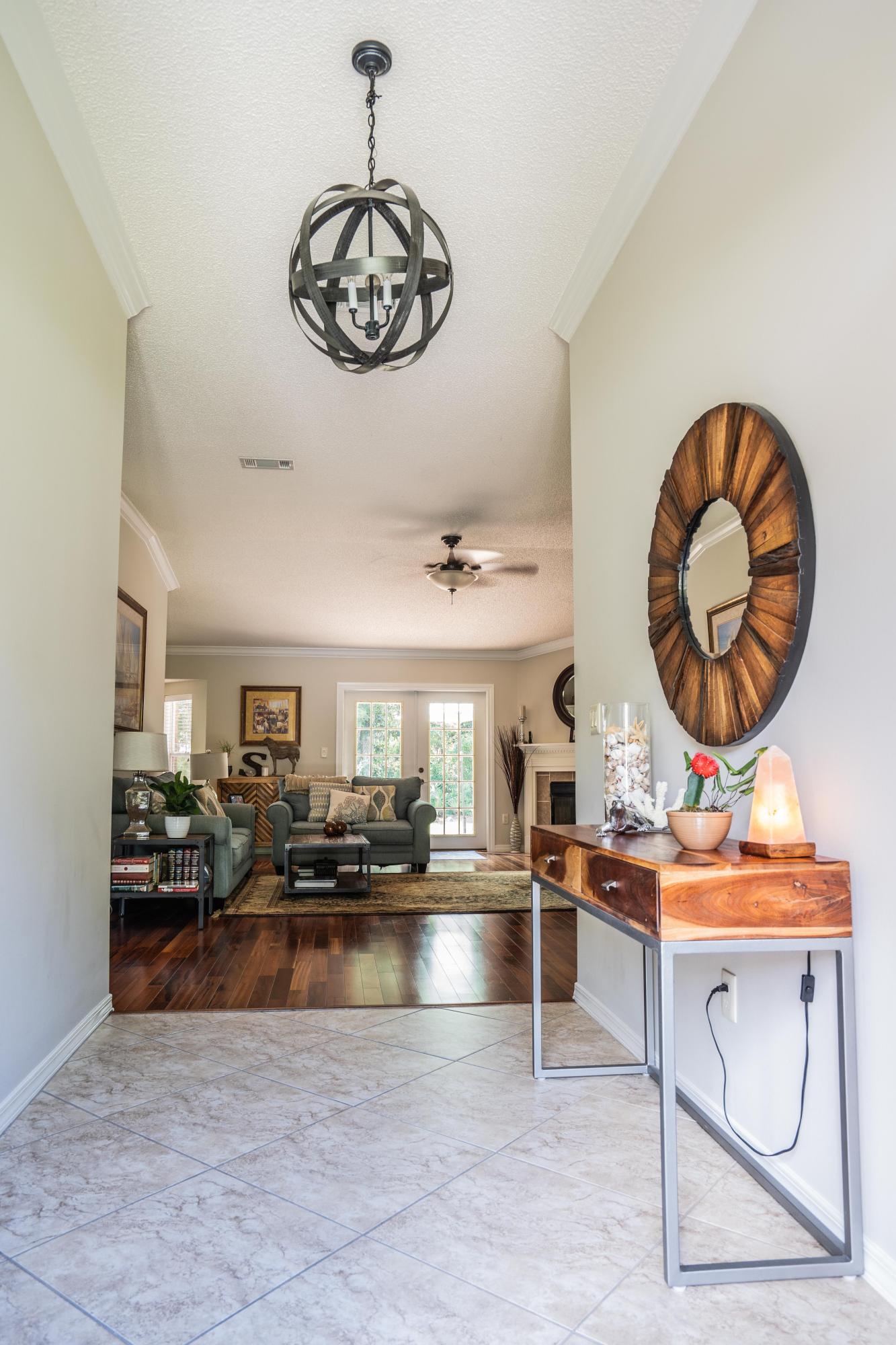4258 Shadow Lane Niceville, FL 32578 - Photo 4 of 36 a living room with fireplace furniture and a chandelier