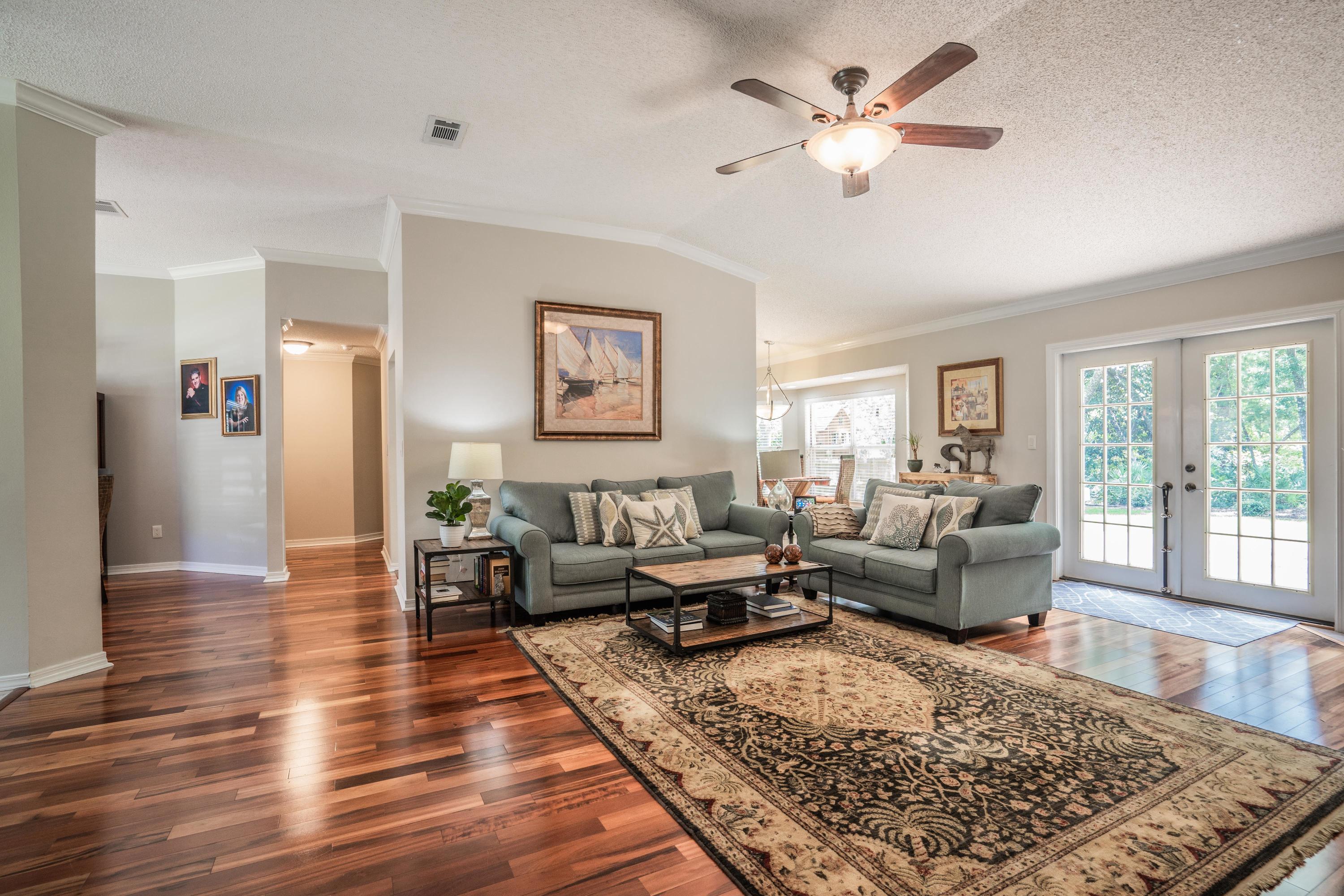 4258 Shadow Lane Niceville, FL 32578 - Photo 8 of 36 a living room with furniture wooden floor and a rug