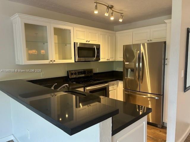 8325 Southwest 72nd Avenue, Unit 205C Miami, FL 33143 - Photo 3 of 14 a kitchen with stainless steel appliances granite countertop a refrigerator a stove and a sink with wooden floor