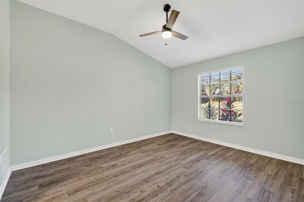 579 Juniper Way Tavares, FL 32778 - Photo 18 of 46 wooden floor in an empty room with a window