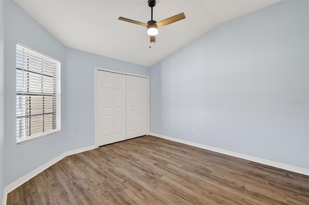 579 Juniper Way Tavares, FL 32778 - Photo 24 of 46 an empty room with wooden floor ceiling fan and windows