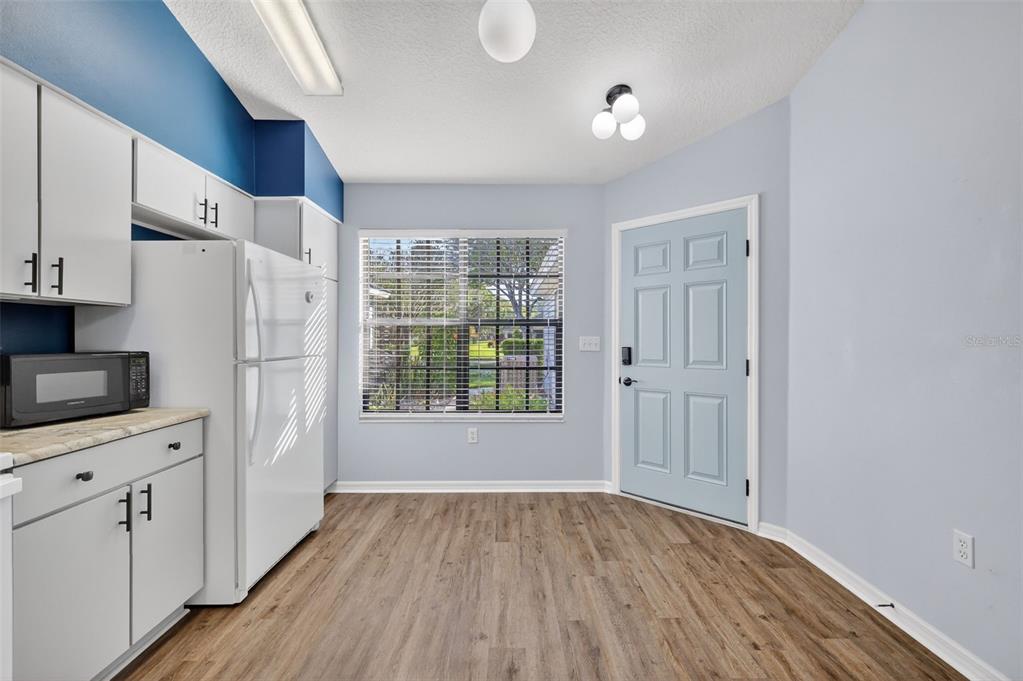 579 Juniper Way Tavares, FL 32778 - Photo 6 of 46 a view of a kitchen with wooden floor and electronic appliances
