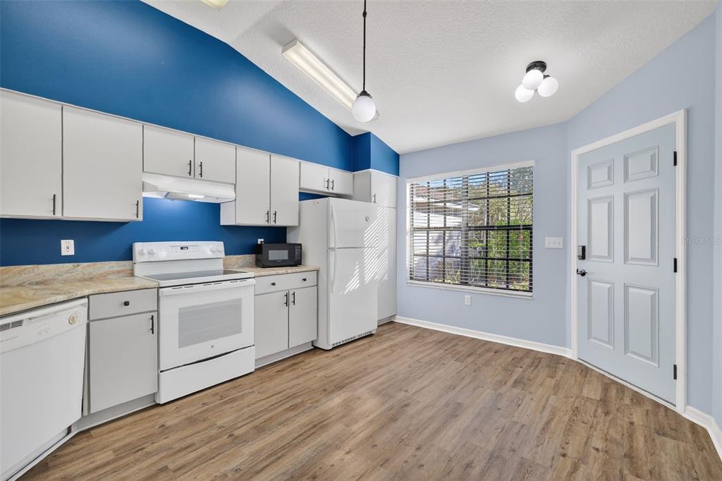 579 Juniper Way Tavares, FL 32778 - Photo 7 of 46 a kitchen with granite countertop white cabinets and white appliances