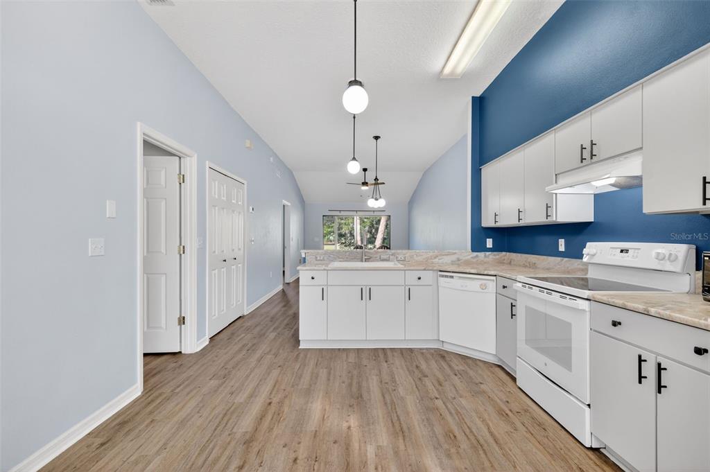 579 Juniper Way Tavares, FL 32778 - Photo 8 of 46 a kitchen with a white cabinets and wooden floor