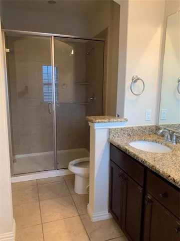 a bathroom with a granite countertop sink a toilet and shower