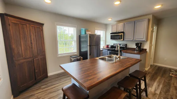 a kitchen with a table chairs refrigerator and cabinets