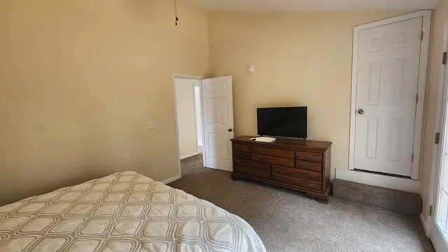 a bedroom with a bed and flat screen tv