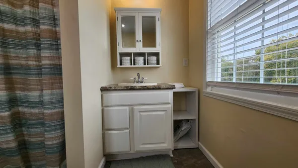 a utility room with a sink cabinets and window