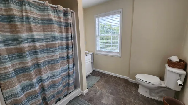 a bathroom with a toilet and a shower curtain