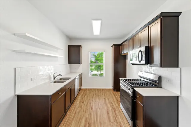 a kitchen with stainless steel appliances a sink stove and refrigerator