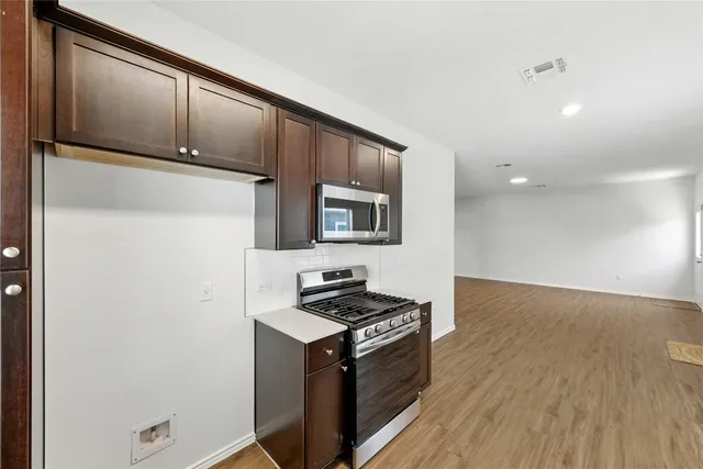 a kitchen with stainless steel appliances a refrigerator and a stove top oven