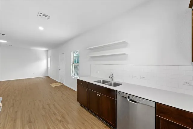 a kitchen with a sink cabinets and wooden floor