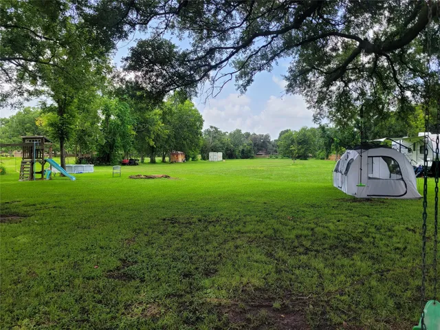 a view of a green field with trees