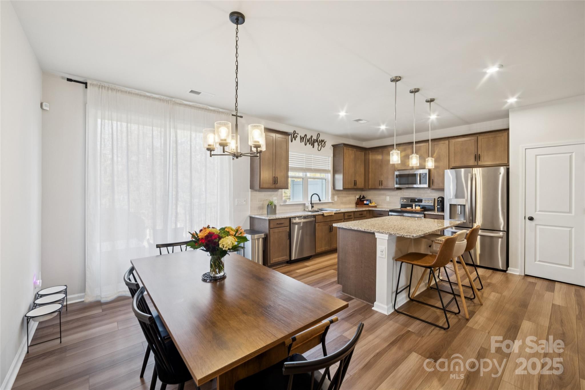 1103 Grays Ml Road Charlotte, NC 28215 - Photo 8 of 25 a open kitchen with stainless steel appliances granite countertop a stove a refrigerator a kitchen island a dining table and chairs with wooden floor