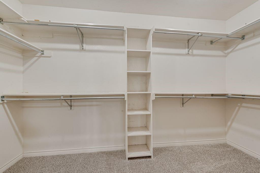 2 Eastshore Road Heath, TX 75032 - Photo 28 of 40 Custom closet system featuring built-in shelving, hanging rods, and light-tone carpeting