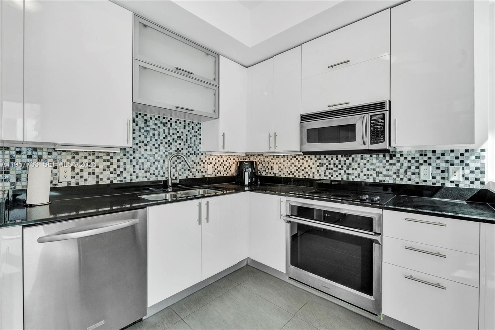 60 Southwest 13th Street, Unit 3400 Miami, FL 33130 - Photo 11 of 50 a kitchen with granite countertop cabinets and stainless steel appliances