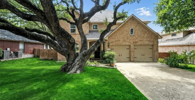a view of a big house with a big yard and large tree