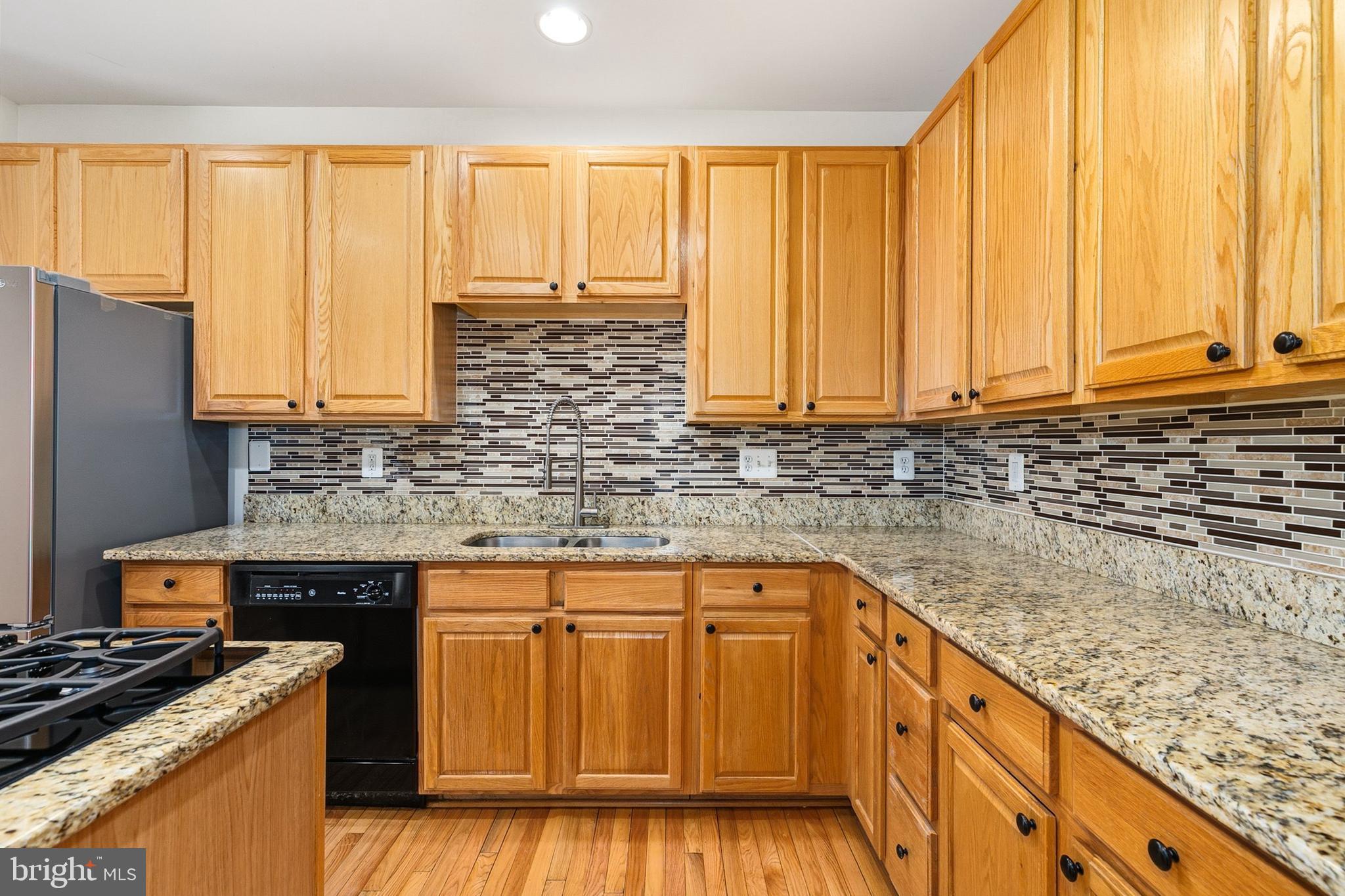9956 Fragrant Lilies Way Laurel, MD 20723 - Photo 11 of 60 a kitchen with stainless steel appliances granite countertop wooden cabinets and a stove top oven