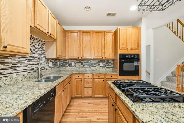 a kitchen with stainless steel appliances granite countertop a refrigerator and a stove top oven