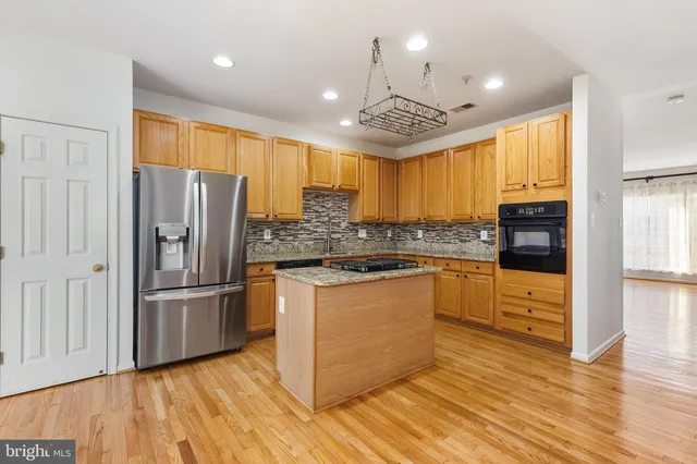 a kitchen with granite countertop stainless steel appliances and wooden cabinets