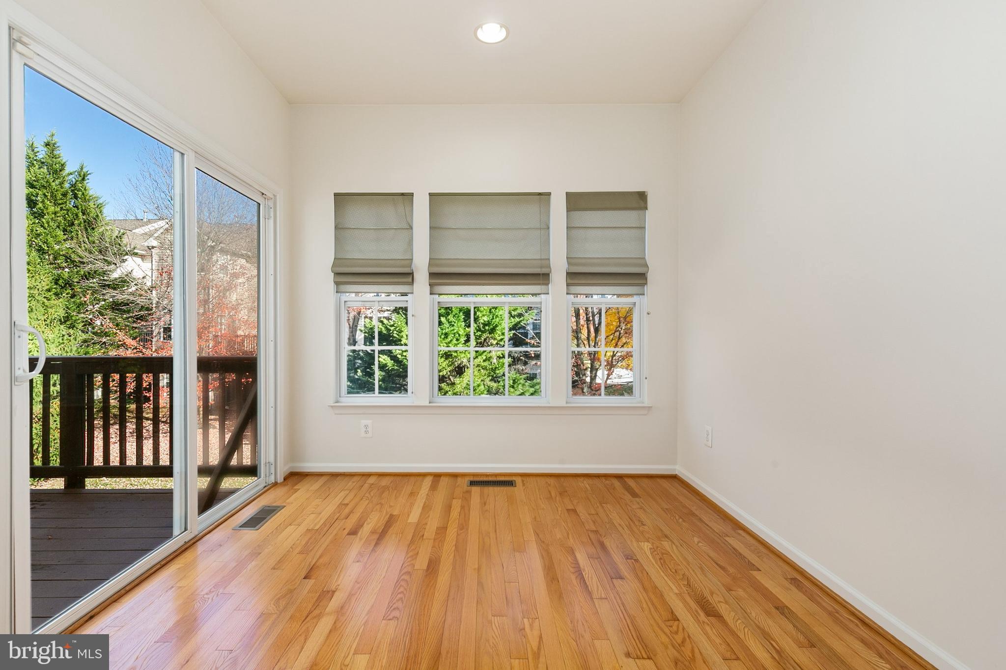 9956 Fragrant Lilies Way Laurel, MD 20723 - Photo 24 of 60 an empty room with wooden floor and windows