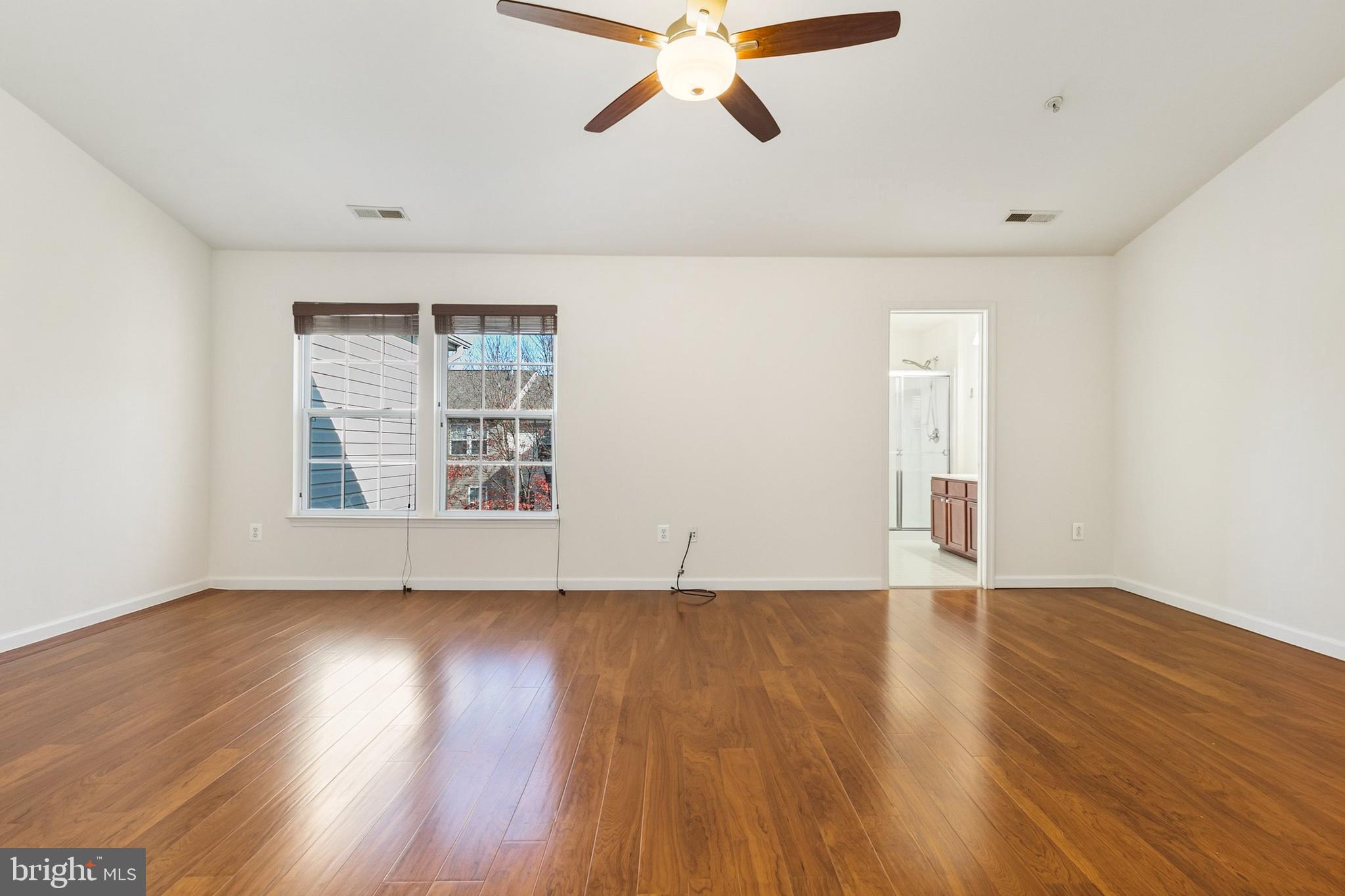 9956 Fragrant Lilies Way Laurel, MD 20723 - Photo 29 of 60 a view of an empty room with wooden floor and a window