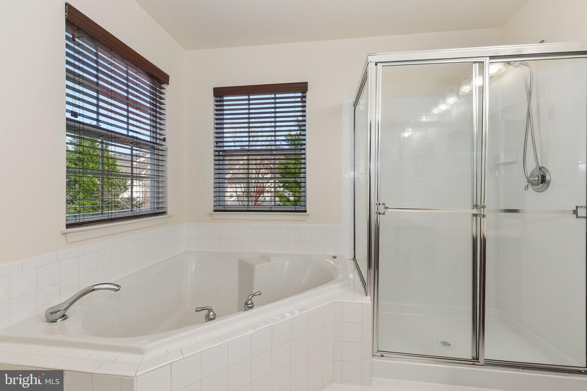 9956 Fragrant Lilies Way Laurel, MD 20723 - Photo 38 of 60 a bathroom with a bathtub and a shower